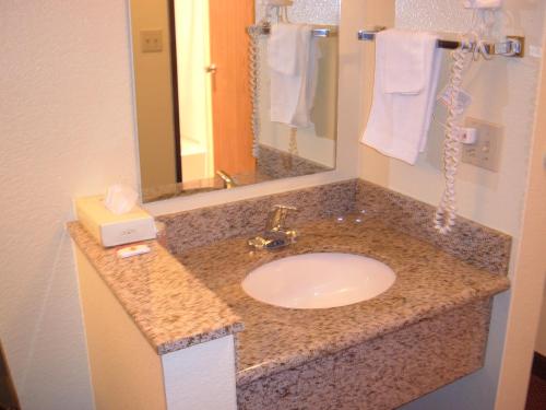 a bathroom counter with a sink and a mirror at Super 8 by Wyndham Moriarty in Moriarty