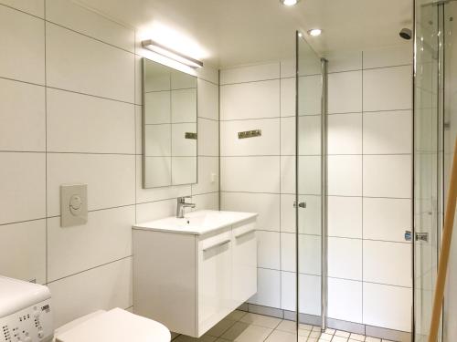 a white bathroom with a sink and a shower at Beverøya Hytteutleie og Camping in Bø
