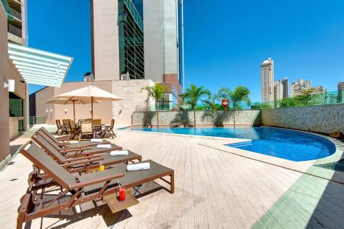 a patio with chairs and a pool on a building at K Hotel in Goiânia