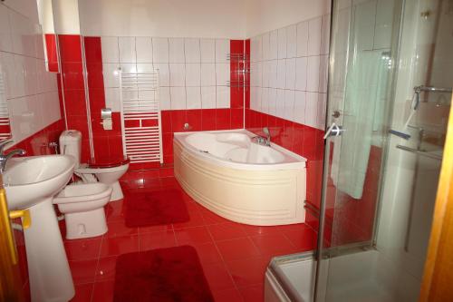 bagno rosso con lavandino e servizi igienici di Pensiunea Casa Benko a Bacău