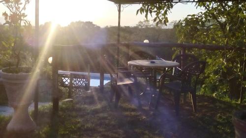 a table and chairs on a patio with the sunset at Le Mimose B&B in Vinci