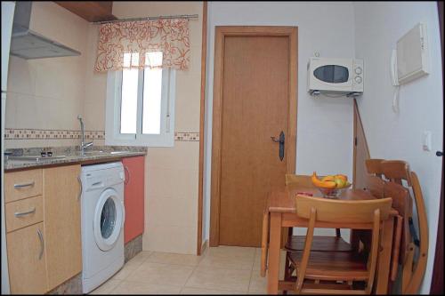 eine Küche mit einem Tisch und einer Waschmaschine in der Unterkunft Apartamento centro de Conil in Conil de la Frontera