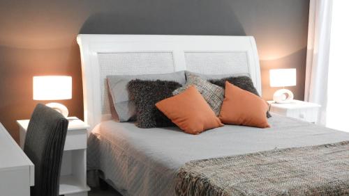 a bedroom with a bed with orange and grey pillows at Arenas del Mar Punta del Este in Punta del Este