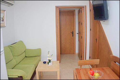 コニル・デ・ラ・フロンテーラにあるApartamento Centro Conilのリビングルーム(緑のソファ、テーブル付)