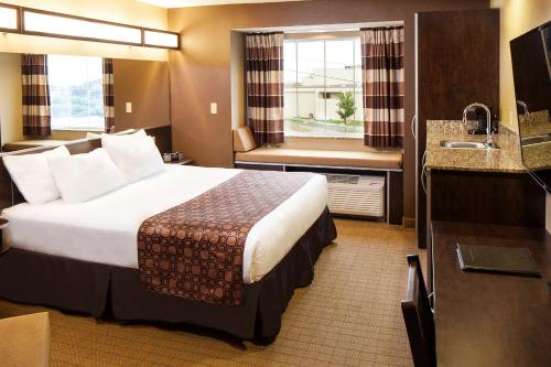 A bed or beds in a room at Microtel Inn & Suites by Wyndham St Clairsville - Wheeling