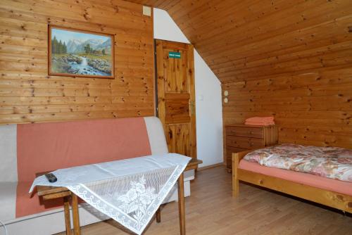 a room with a bed and a bench in a cabin at Ubytování u rybníka Bořetice in Bořetice