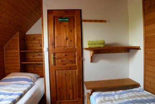 a small bedroom with two beds and a door at Ubytování u rybníka Bořetice in Bořetice
