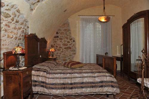 a bedroom with a bed and a stone wall at Ancaiano Country House in Ferentillo