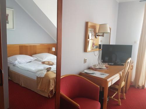 a bedroom with a bed and a desk with a television at Willa Rawia 2 in Rewal