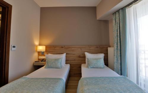 a hotel room with two beds and a window at Kule Hotel in Canakkale