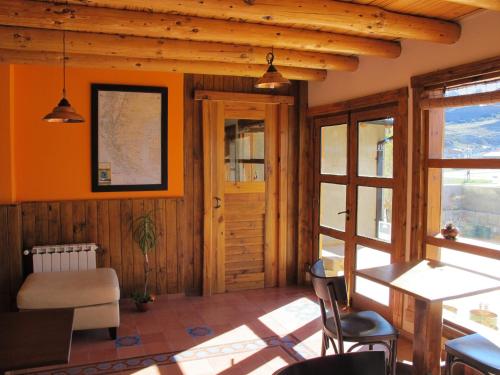 a living room with orange walls and wooden ceilings at Patagonicus in El Chalten