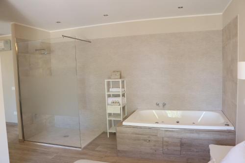 a bathroom with a tub and a glass shower at Le camere di Villa Incanto in Colonnella