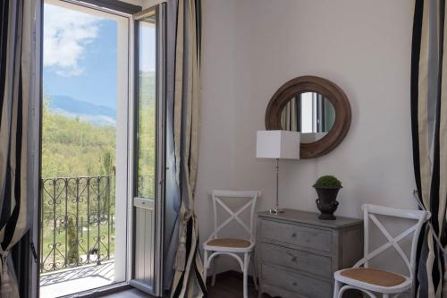 a room with a balcony with a dresser and a mirror at Casale Virginia in Cesariano