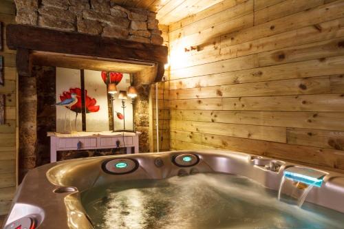 baño con bañera en una pared de madera en Auberge Du Cheval Blanc, en Baud