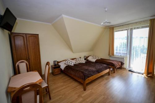 ブコビナ・タトシャンスカにあるWilla Bukowinaのベッドルーム1室(ベッド1台、大きな窓付)