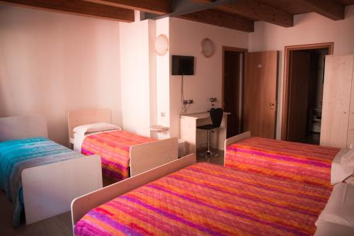 a room with two beds with colorful blankets at La Casa del Sogno in Monteforte dʼAlpone