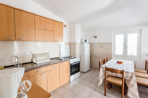 a kitchen with wooden cabinets and a table with a table cloth at Luštica Apartments in Lustica