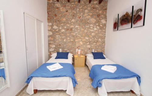 a room with two beds and a stone wall at Casa de Vacaciones Ribot in Ariany