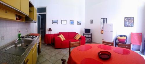 テッラジーニにあるTerrasini Siracasaのキッチン、リビングルーム(赤いソファ付)