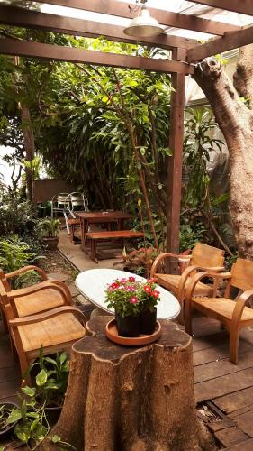 a patio with chairs and a table with flowers on it at Lamphuhouse Bangkok in Bangkok