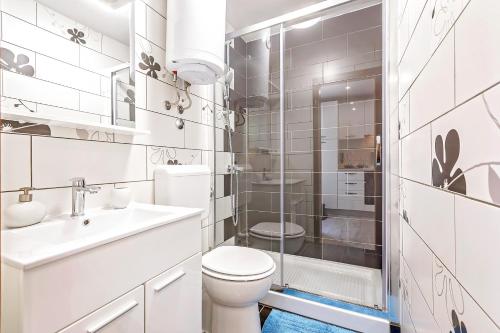a white bathroom with a toilet and a shower at Apartment Irene in Poreč