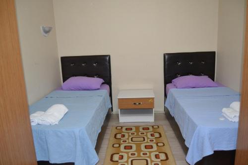 トラブゾンにあるBirlik Apart Hotelの紫色の枕が備わる客室内のベッド2台