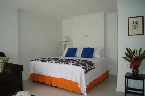 a bedroom with a large bed with blue pillows at Alva mae in Ocho Rios