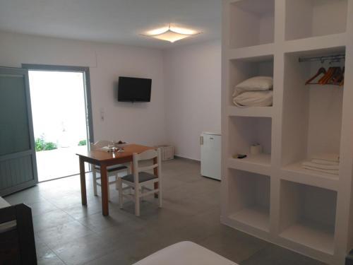 a living room with a table and a dining room at Milos Bay Suites in Adamas
