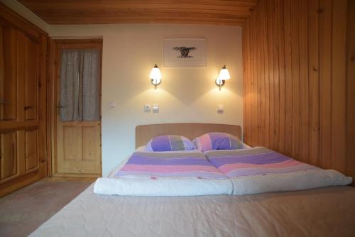 a large bed in a bedroom with two lamps at Inkliuzas in Nida