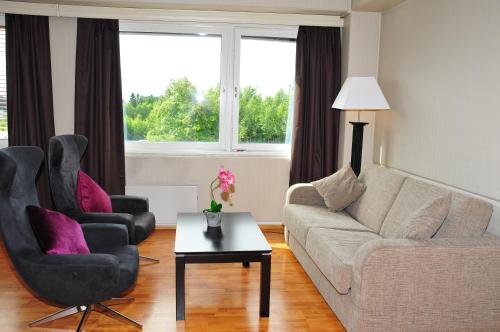a living room with a couch and two chairs and a table at Best Western Leto Arena in Dal