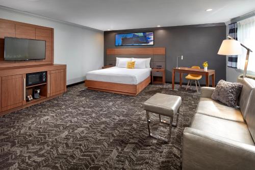 Habitación de hotel con cama y sofá en Studio Inn & Suites at Promenade Downey, en Downey