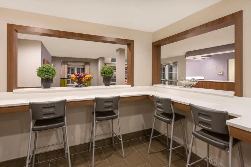 a bar with stools in a room with a mirror at Microtel Inn & Suites by Wyndham in Sandston