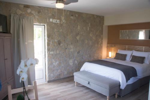 une chambre avec un lit et un mur en pierre dans l'établissement The Fig Boutique Suites, à Salir de Porto