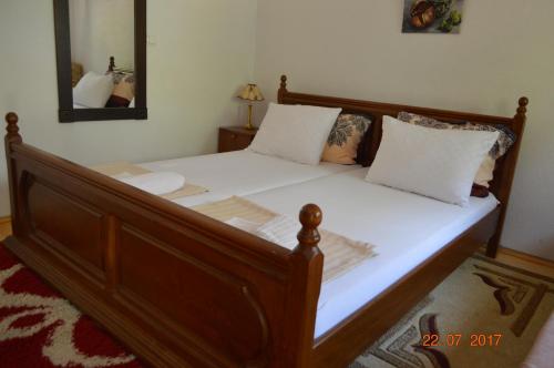 een bed met witte lakens en kussens in een slaapkamer bij Apartment Enny in Blagaj