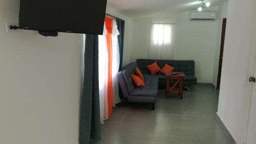 a living room with a blue couch and orange pillows at Hotel Gerald in Contadora