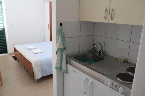 een kleine keuken met een wastafel en een bed bij Camp Krka in Lozovac