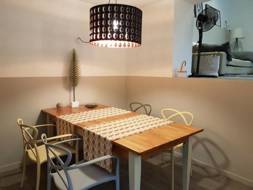 a dining room table with chairs and a pendant light at les bignones in Uzès