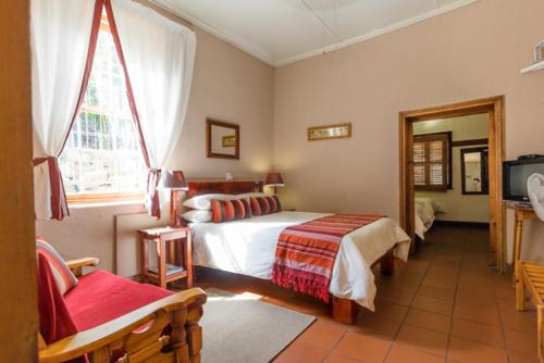 a bedroom with a bed and a window and a tv at NANNA ROUS' TOWN HOUSE in Colesberg