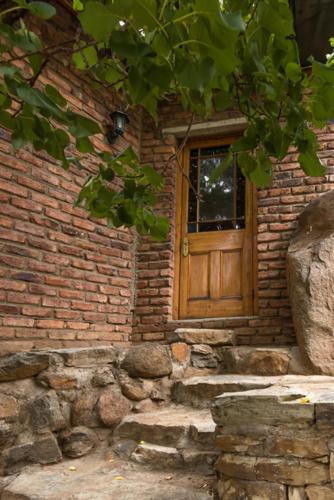 a brick building with a wooden door and stairs at NANNA ROUS' TOWN HOUSE in Colesberg