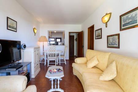 a living room with a couch and a tv and a table at Casa Sol e Praia in Luz