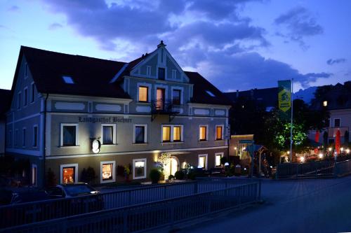 a large white building on a city street at night at Landgasthof Buchner in Admont