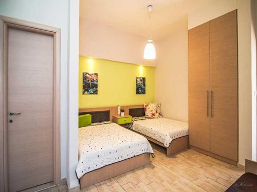 a bedroom with two beds and a door to a room at Elli in Velika