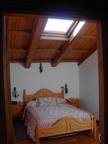 a bedroom with a wooden bed with a window at A Salanova in Salcedo