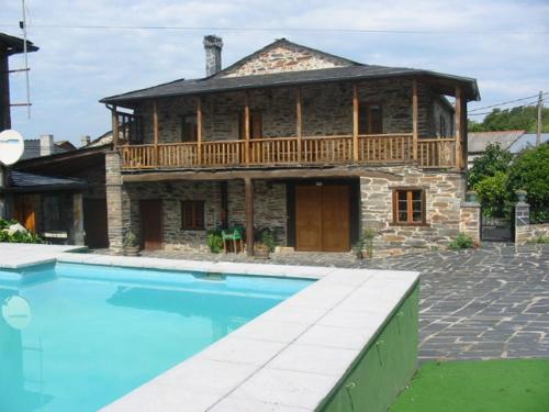a large stone house with a swimming pool in front of it at A Salanova in Salcedo