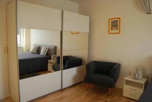 a bedroom with a large mirror and a bed and a chair at Ferienwohnung Aronia in Warlow