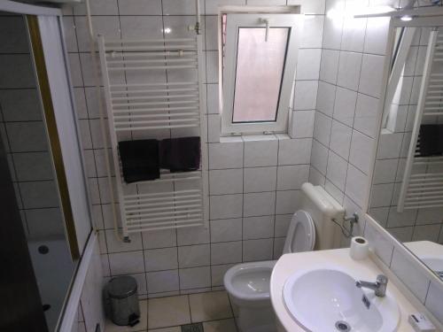 a white bathroom with a sink and a toilet at Skopje Panorama in Skopje