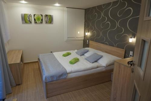 ein Schlafzimmer mit einem Bett mit zwei grünen Kissen darauf in der Unterkunft Apartmán Štěpánka in Ratíškovice