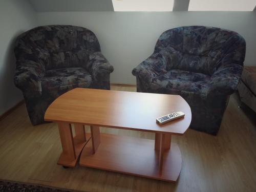 a living room with a coffee table and a remote control at Pensiunea Apolka Panzió in Covasna