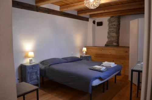 a bedroom with a bed and a table and lights at Rota d'Amont in Stroppo