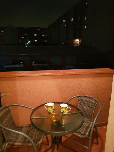 two coffee cups sitting on a table on a balcony at Apartment GEA 1 in Novi Sad